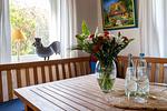 Wohnbereich mit Tisch und Blumenarrangement - Seeräuber - Top-Hundeurlaub