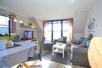 Sofa, Sessel, Hocher und TV im Wohnzimmer - Wohnung 14-5 - Top-Hundeurlaub