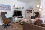 Wohn-/Essbereich mit Doppelschlafcouch, Couchtisch, Sessel und TV - Aparthotel Ostseeallee 2-18 - Top-Hundeurlaub