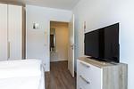 Schlafzimmer mit Boxspringbett und TV - Aparthotel Ostseeallee 2-18 - Top-Hundeurlaub