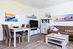 Wohn-/Essbereich mit Couch, Couchtisch, TV, Esstisch und Sitzgelegenheiten - Aparthotel Ostseeallee 3-25 - Top-Hundeurlaub