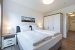 Schlafzimmer mit Boxspringbett und Kleiderschrank - Aparthotel Ostseeallee 3-25 - Top-Hundeurlaub
