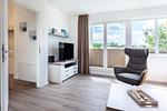 Wohn-/Essbereich mit Sessel, TV und Zugang zur Dachterrasse - Aparthotel Ostseeallee 3-28 - Top-Hundeurlaub