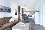 Wohn-/Essbereich mit Doppelschlafcouch, Couchtisch, Sessel und Küchenzeile - Aparthotel Ostseeallee 3-28 - Top-Hundeurlaub