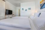 Schlafzimmer mit Doppelbett, Kleiderschrank und TV - Aparthotel Ostseeallee 3-28 - Top-Hundeurlaub
