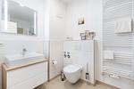 Badezimmer "2" mit Waschtisch, Spiegel und WC - Aparthotel Ostseeallee 3-28 - Top-Hundeurlaub