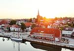 Blick auf Neustadt in Holstein aus der Luft bei Sonnenaufgang - Romantische Ferienwohnung am Hafen mit gratis Bettwäsche-Paket und Terrasse - Top-Hundeurlaub