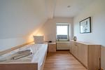 Schlafzimmer mit Einzelbett und Sideboard - Hus Strandkieker 08 - Top-Hundeurlaub