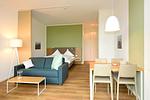 Wohn/ Essbereich mit Couch und Esstisch - Aparthotel Anna Düne 0-02 - Top-Hundeurlaub