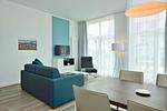 Wohn/ Essbereich mit Couch, Fernseher und Esstisch - Aparthotel Anna Düne 0-06 - Top-Hundeurlaub