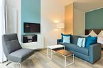 Wohn/ Essbereich mit Couch, Sessel und Fernseher - Aparthotel Anna Düne 0-09 - Top-Hundeurlaub