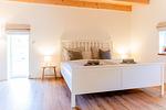 Schlafzimmer mit Doppelbett (180x200cm) und Gartenblick - Ferienwohnung Hanna im Reethus Mühlenlund - Top-Hundeurlaub