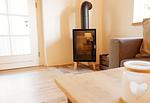 Wohnbereich mit Kaminofen (Starter-Korb Holz inkl.) - Ferienwohnung Hanna im Reethus Mühlenlund - Top-Hundeurlaub