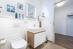 Badezimmer mit Waschtisch, Spiegel und WC - Aparthotel Ostseeallee 2-09 - Top-Hundeurlaub