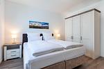 Schlafzimmer mit Boxspringbett und Kleiderschrank - Aparthotel Ostseeallee 2-12 - Top-Hundeurlaub