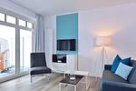 Wohn/ Essbereich mit Couch, Sessel und Fernseher - Aparthotel Anna Düne 1-16 - Top-Hundeurlaub