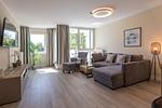 Ferienwohnung Godewind Aparthotel Zingst - Blick ins offene Wohnzimmer mit Couch und Sessel - Godewind - Top-Hundeurlaub