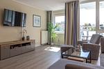 Ferienwohnung Godewind Aparthotel Zingst - Wohnzimmer mit TV und Sessel - Godewind - Top-Hundeurlaub