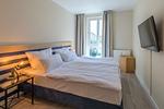 Ferienwohnung Godewind Aparthotel Zingst - helles Schlafzimmer mit gemütlichem Doppelbett und Fenster - Godewind - Top-Hundeurlaub