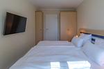 Ferienwohnung Godewind Aparthotel Zingst - Blick ins Schlafzimmer mit Doppelbett, TV und Kleiderschränken - Godewind - Top-Hundeurlaub