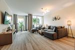 Ferienwohnung Godewind Aparthotel Zingst - Blick ins offene Wohnzimmer mit Couch und Sessel - Godewind - Top-Hundeurlaub