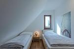 Schlafzimmer mit Einzelbetten und Nachttisch mit Nachttischlampe - Hafenhaus Kapitänsdeck - Top-Hundeurlaub