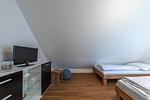 Schlafzimmer mit zwei Einzelbetten und Komode und TV - Hafenhaus Kapitänsdeck - Top-Hundeurlaub