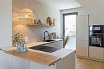 Moderne Küche mit Holzarbeitsplatte und Fenster. - Strandwohnung 02 - Buhne 12 - Top-Hundeurlaub