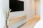 Schlafzimmer mit Fernseher und Holzkommode - Strandwohnung 01 - Buhne 12 - Top-Hundeurlaub