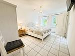 Großes Schlafzimmer mit Doppelbett, Fenstern, TV und Kleiderschrank - Krischan - Ruhige Ferienwohnung unweit vom Meer - Top-Hundeurlaub