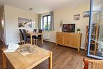 Wohnzimmer mit Esstisch und TV - Wohnung 02-1 - Top-Hundeurlaub