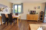 Wohnzimmer mit Esstisch und TV - Wohnung 02-1 - Top-Hundeurlaub