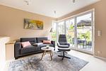 Helles Wohnzimmer mit Sofa und Zugang zur Terrasse - Windlooper 1 - Top-Hundeurlaub