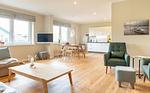 Ferienwohnung Nordkap in Wittdün/Amrum   Blick vom Wohnzimmer in die offene Küche mit Esstisch, Leseecke und TV - Haus Jungnamen Sand - Wohnung Nordkap - Top-Hundeurlaub