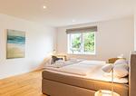 Ferienwohnung Nordkap in Wittdün/Amrum Doppelbett im ersten Schlafzimmer und Schreibtisch mit Lampe - Haus Jungnamen Sand - Wohnung Nordkap - Top-Hundeurlaub