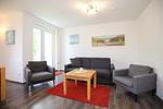 Wohnzimmer mit Sofa und Sessel - Wohnung 012 - Top-Hundeurlaub