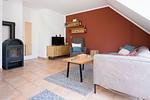 Wohnzimmer mit Sofa, Fernseher und Holzofen - Strandoase - Wohnung 3 - Top-Hundeurlaub