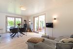 Wohnzimmer mit TV-Ecke, Esstisch und Ofen - VITA Sonnholm - Top-Hundeurlaub