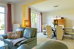 Helles Wohnzimmer mit Sofa und Esstisch - An den Boddenwiesen 02 - Top-Hundeurlaub