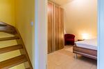 Schlafzimmer mit Bett und rotem Sessel - An den Boddenwiesen 02 - Top-Hundeurlaub