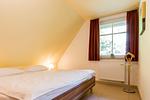 Schlafzimmer mit Doppelbett und Fenstern - An den Boddenwiesen 02 - Top-Hundeurlaub