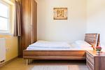 Schlafzimmer mit Einzelbett und Nachttisch - An den Boddenwiesen 02 - Top-Hundeurlaub