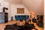 Wohnzimmer mit blauer Couch und Fernseher - Haus Ostseenixe 03 - Top-Hundeurlaub