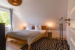 Helles Schlafzimmer mit Holz-Bett und Fenster - Haus Ostseenixe 03 - Top-Hundeurlaub