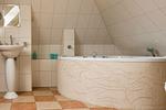 Badezimmer mit runder Badewanne und Waschbecken. - Haus Ostseenixe 05 - Top-Hundeurlaub