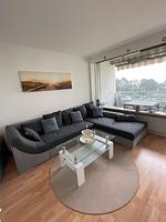 Wohnzimmer mit L-Sofa und Blick auf den Balkon - Ferienpark App. 595/5  - Sierksdorf - Top-Hundeurlaub