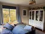 Gemütlicher Wohnbereich mit Sofa und Blick in die Natur - Häxans Hus - Top-Hundeurlaub