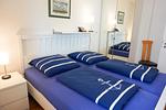 Gemütliches Schlafzimmer mit maritimer Bettwäsche und modernen Annehmlichkeiten. - Berliner Hof App. 212 - Top-Hundeurlaub